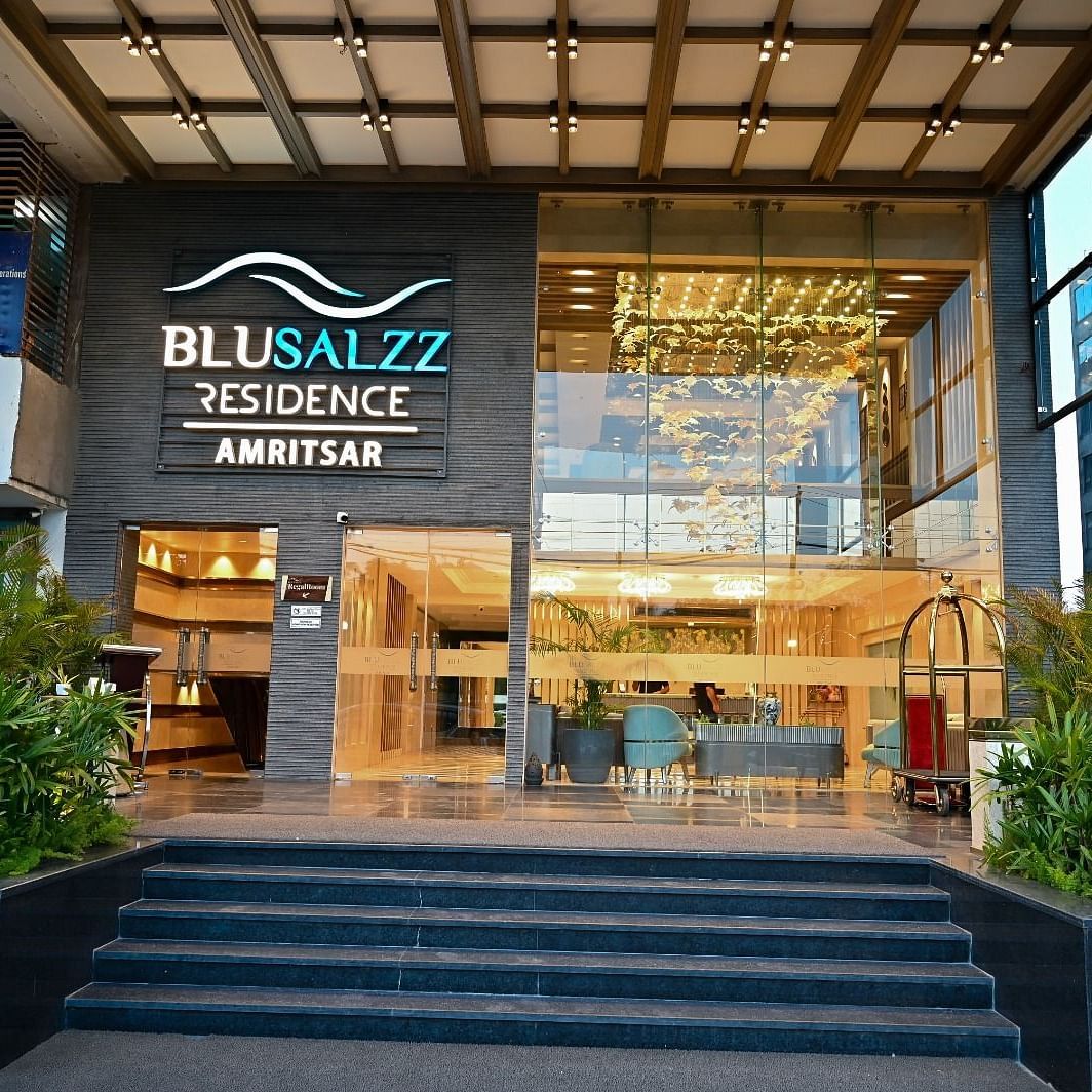 Hotel entrance with neatly arranged plants on both sides at BluSalzz Residence, Amritsar.